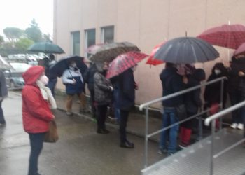 La fila sotto la pioggia prima di entrare al centro vaccinale