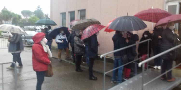 La fila sotto la pioggia prima di entrare al centro vaccinale