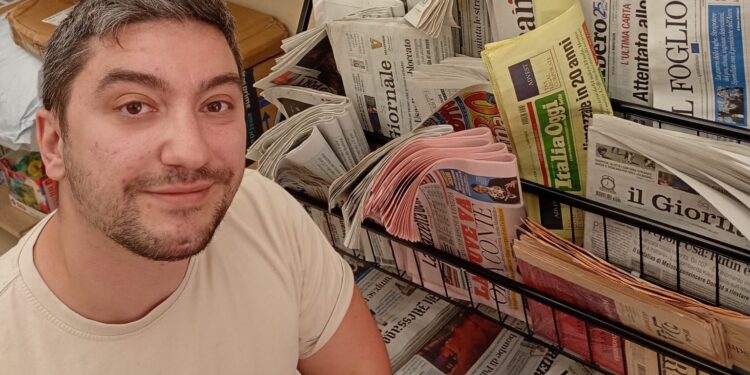 Francesco Porcacchia davanti al corner di giornali all'interno della sua tabaccheria